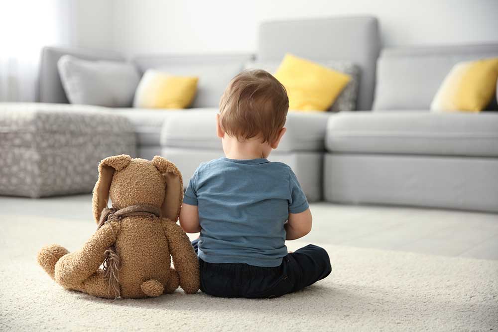 sensory processing disorder boy sitting with a Bear stuffed animal